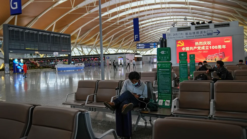 Passagerare väntar vid tomma informationstavlor på Pudong-flygplatsen i Shanghai. Alla flygningar ställdes in på stadens två internationella flygplatser på söndagen på grund av tyfonen In-fa.