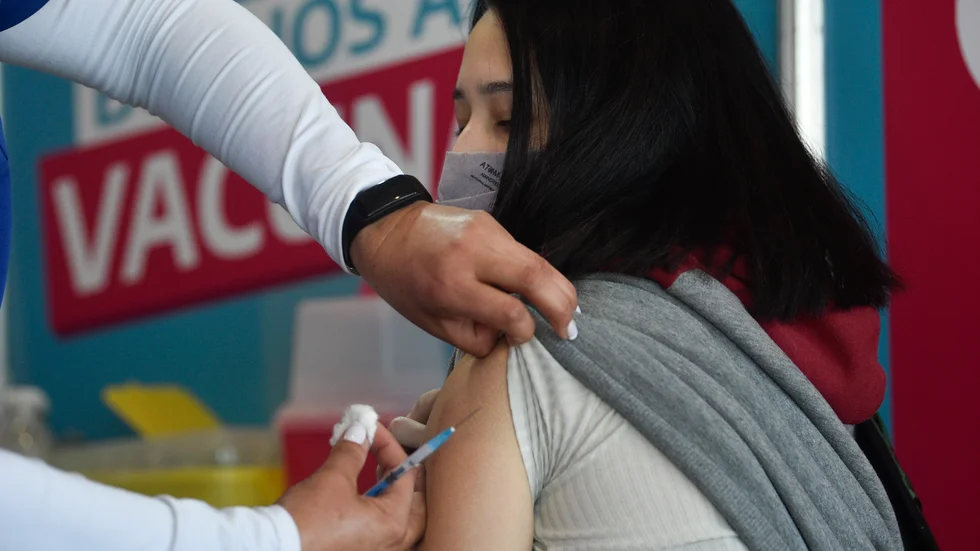 En ung kvinna i Argentina får en dos vaccin som donerats av USA.