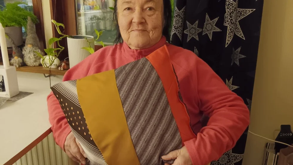 Maj-Britt Larsson med en av sina många kuddar som hon syr och säljer för hjälp till cancerforskningen.