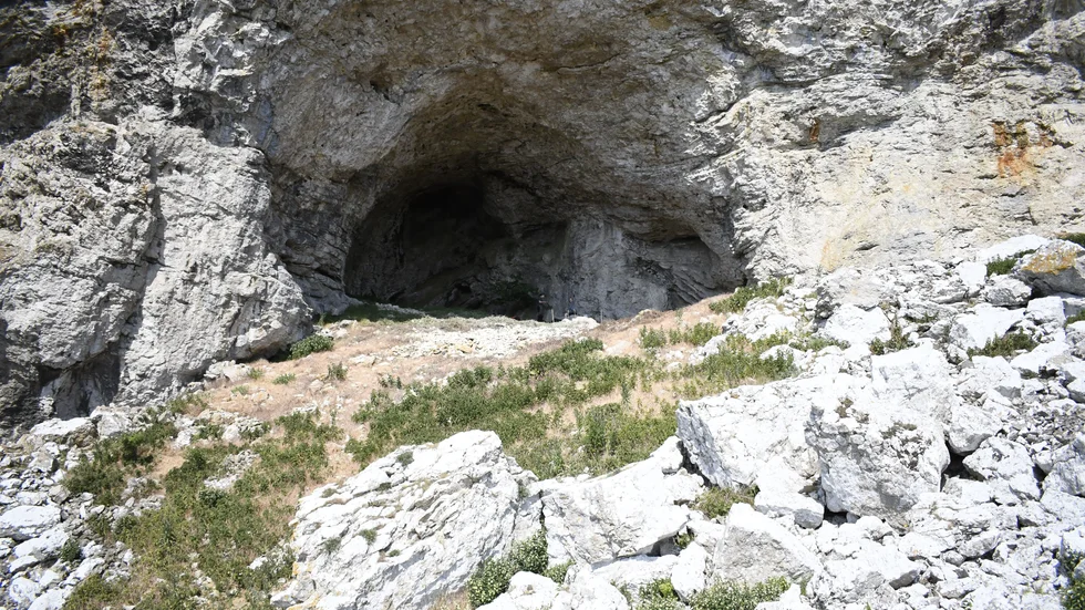 Grottan Sudervagnhus är stor öppning i berget på Lilla Karlsö. Tittar man noggrant ser man två personer i mynningen, nära mitten. 