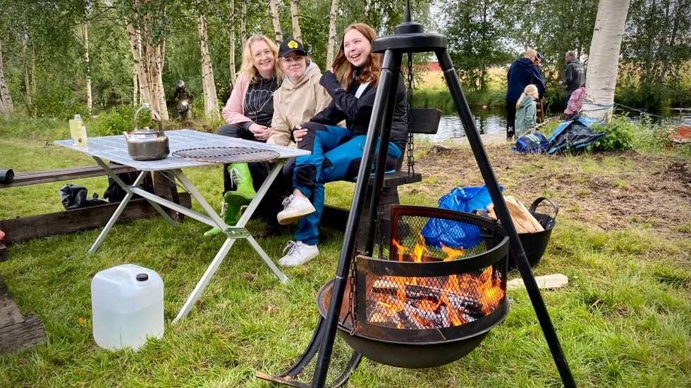 Louise Holm, Evelina Berglund och Thea Nyberg myser vid elden.  "Vi har hört att någon fått 25 kräftor, men kvällen är ung och vi hoppas på god fångst", säger Louise.