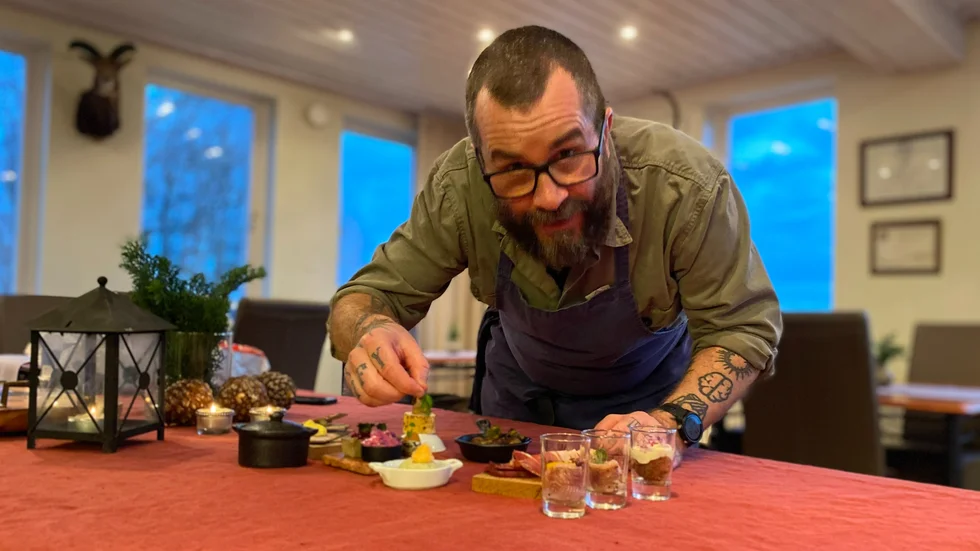 Kökschefen Fredrik Kämpenberg sätter sin sista lilla touch på maten.