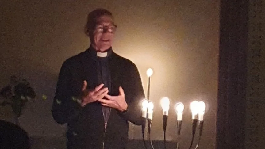 Stig Sundström talar i stearinljusets sken.
