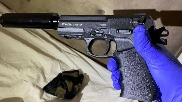 En ombyggd startpistol med ljuddämpare var ett av de vapen som hittades i kvinnans bostad. 