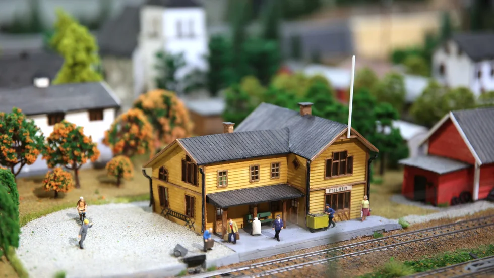 Vid det gamla stationshuset pågår livet för fullt. Antalet tågspår i modellen får man dock ta med en nypa salt.