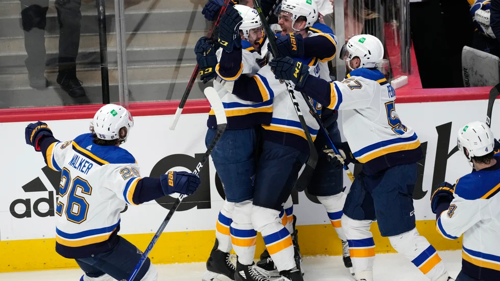 St. Louis center Tyler Bozak, andra från vänster, blir överfallen av sina lagkamrater efter segermålet 5–4 i förlängningen i den femte kvartsfinalmötet mot Colorado.