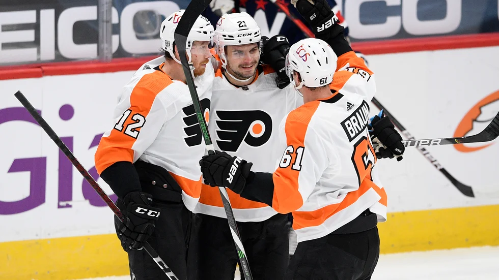 Philadelphias Scott Laughton, i mitten, firas efter sitt tredje mål mot Washington.