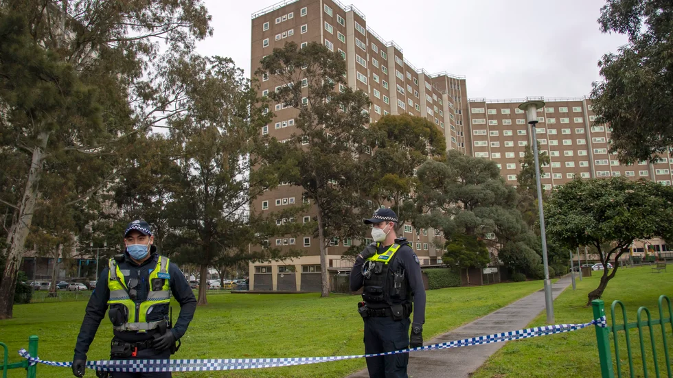 Polis bevakar en fastighet i Melbourne som spärrats av på grund av virusspridning. Bild från början av juli.