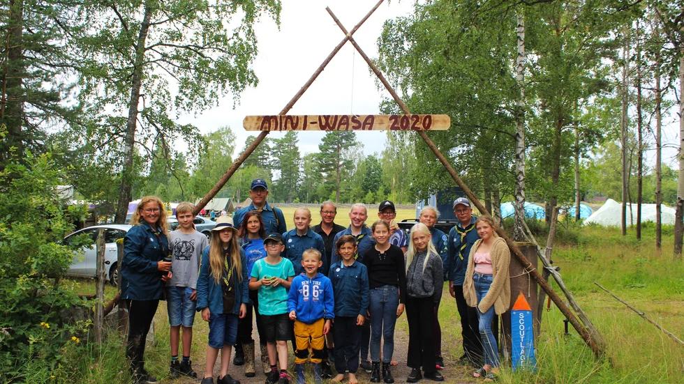 Här ses Marsbäckens scoutkår samlade under skylten som avslöjar temat på årets sommarläger.