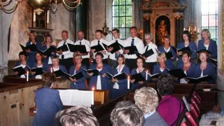 Koret i S:ta Gertruds kyrka är trångt. Men Aspelandskören trängde ihop sig utan besvär, med sin ledare, Anne-Marie Daag-Albrektsson vid pianot.