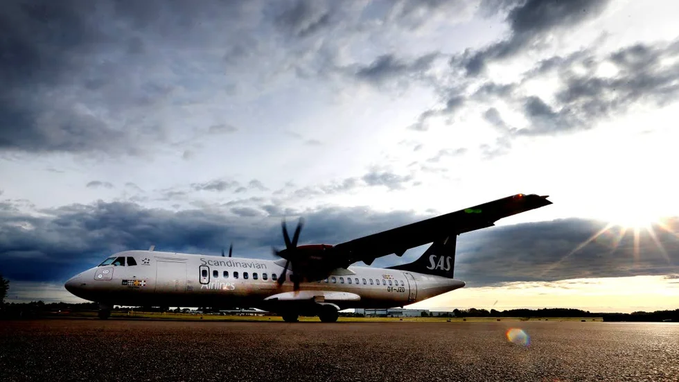 Moln över flyg. Ett plan på Linköpings flygplats.