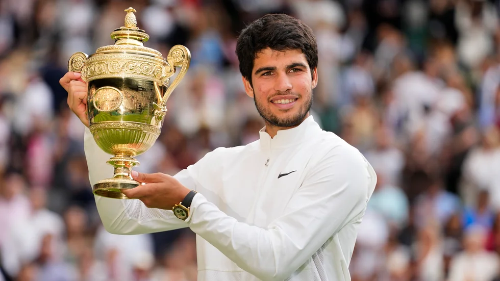 Carlos Alcaraz håller upp trofén.