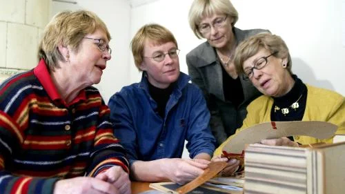 Fyra damer med spetskompetens i ett av rummen i Gottfrid Larssongården där ett spetsmuseum kommer att öppnas till nästa sommar. Fr v Gudrun Gunnarsson, Marianne Andersson, Birgitta Högemark och Kristina Malmberg. De tittar på ett mönster som någon lagat för länge sedan. Bild: ÅKE KARLSSON