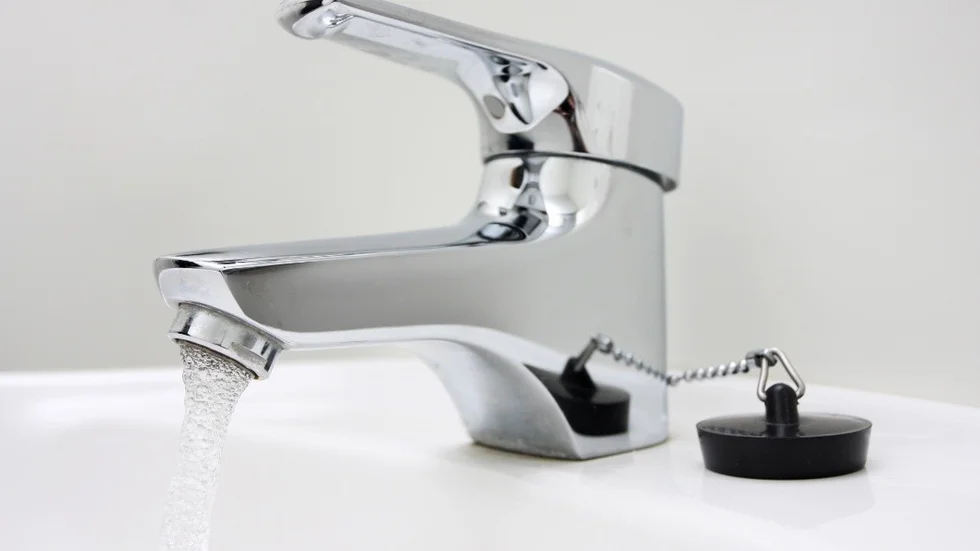 chrome faucet on a sink, running water