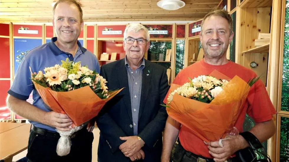 Företagarnas regionchef Kjell Hjelm flankerad av bröderna Folke och Sven Stenvall då de uppvaktats med blommor. Systern Anna Flink var på annan ort vid tillfället.