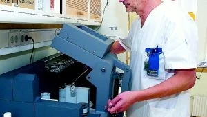 Thomas Frånlund är röntgensjuksköterska och en av dem som utför själva undersökningen med PET/CT-maskinen. "Man får jobba snabbt och hålla avstånd till patienten", säger han och visar den radioaktiva sockerlösningen (vänstra bilden) som sprutas in på patienten. Hörnrummet där patienten får injektionen är inte valt av en slump. Det ligger så att så få människor som möjligt ska bli utsatta för radioaktivitet.