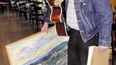 Med pappa Martins målning under armen, partituret och det aktuella arbetsredskapet gitarren, går John Lidström till möte med dirigent och Symfoniorkestern. Hans symfoni nr 1 ska spelas 14 mars istället för i morgon, då ska den vara mer färdig.
FOTO: ROBERT SVENSSON