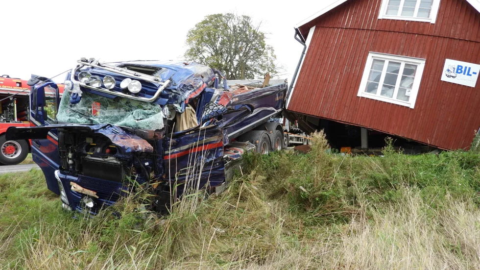 Lastbilen har kolliderat med en verkstadsbyggnad som riskerar att rasa.