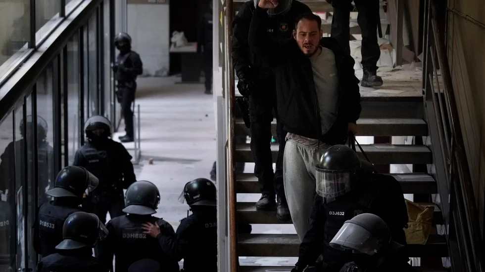 Rapparen Pablo Hasél förs ut av polis från universitetet i Lleida i Katalonien under tisdagen.