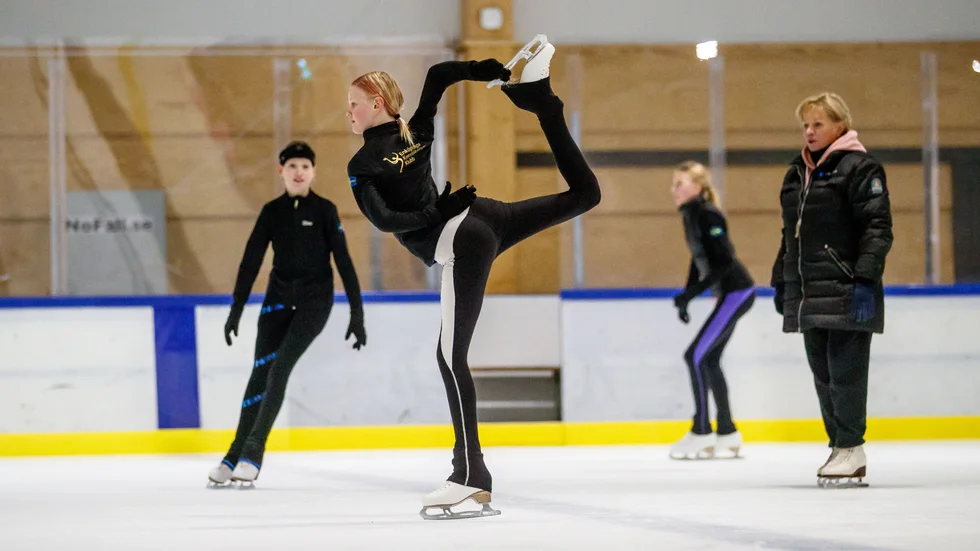 Svea Ternvald gör en Biellmannpiruett, Ellen Persson och Emilia Wallebring i bakgrunden under ett av deras pass för den rutinerade tränaren Tatiana Agafonova. 