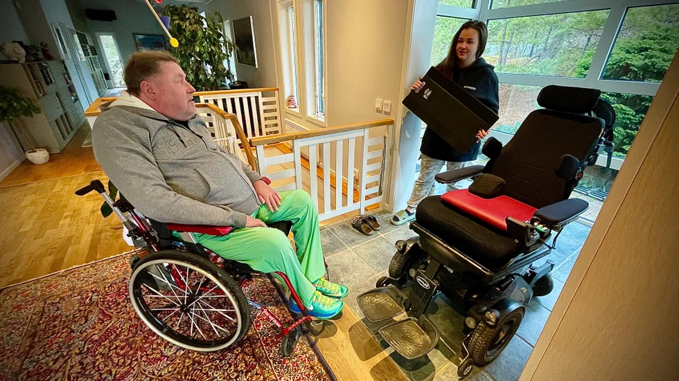 Greger Lundbergs assistent Johanna Markkanen visar glidbrädan som tidigare användes för att dra över honom till permobilen. "Jag förstår inte varför det inte längre ska gå. Flyttar de inga invalider i Trosa med glidbräda eller gäller det bara mig?", frågar han sig.