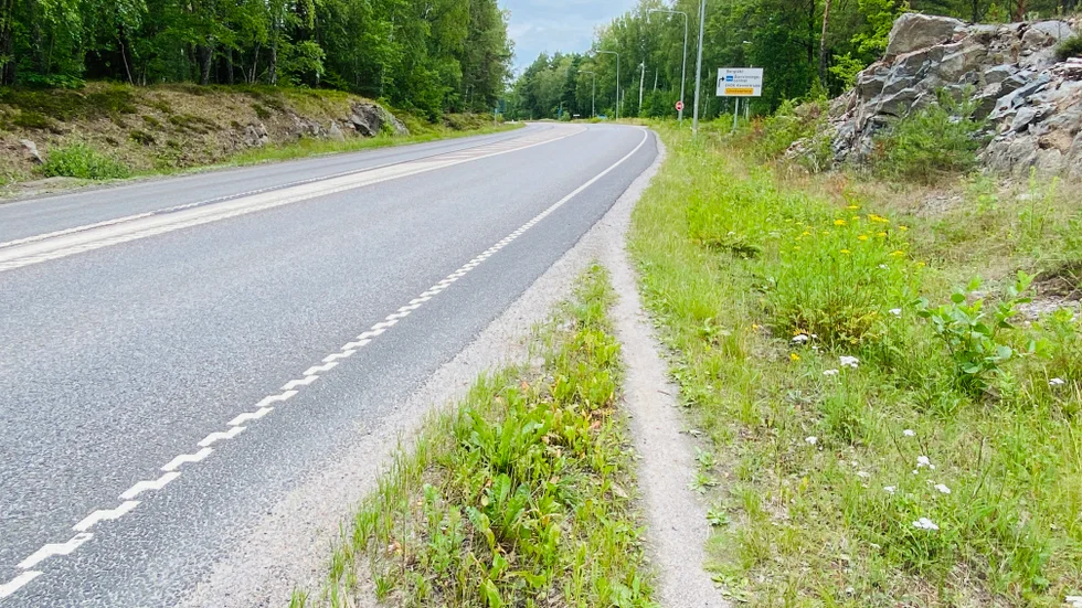 Den sökande grannen menar att ska man ta sig förbi dunkarna måste man åka av vägen och att utryckningsfordon inte kommer förbi. Vägen på bilden är inte den vägen som det handlar om. 