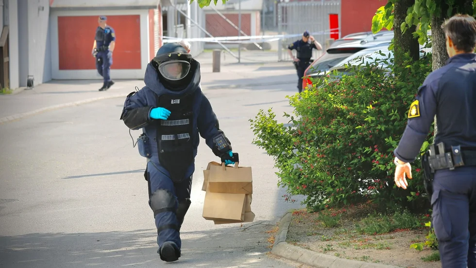 Personal från nationella bombskyddet lämnade platsen med bruna papperspåsar. Det är för oss okänt vad som finns i dem.