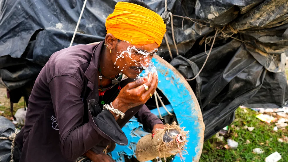 En man svalkar sig med vatten i Latitpurdistriktet i delstaten Uttar Pradesh.