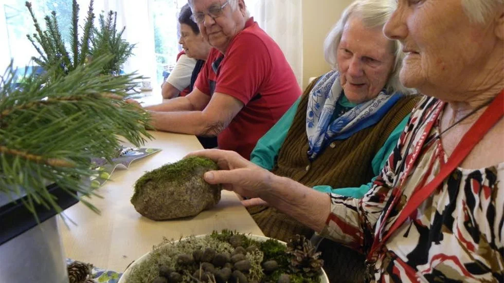 Ulla Jonsson och Karin Karlsson känner och luktar på växter och stenar under gökottan på Kungsängen.