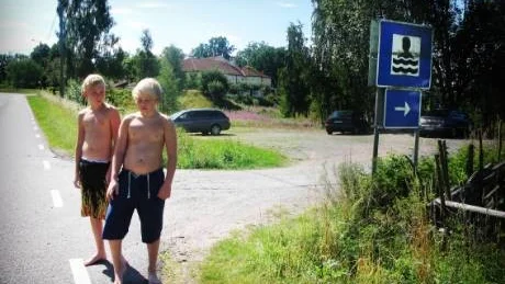 Christoffer Andersson och Jonny Möller tvingas gå över den farliga vägen i Hjorted för att komma till sin badplats. Nu har ortsborna fått nog och vill att vägverket ska bygga en gångväg. Foto: Margareta Ljungblad