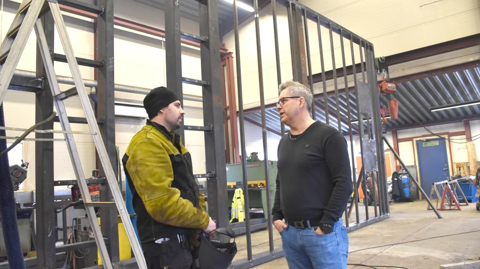 Svetsaren Simon Neitola (t v) och Imus vd Ronny Persson samtalar framför en värmepanneplatta som är ungefär 14x4 meter stor och ska levereras till Ulricehamn.