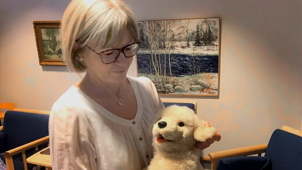 Carina Kemppainen visar en digital hund som används inom verksamheten.