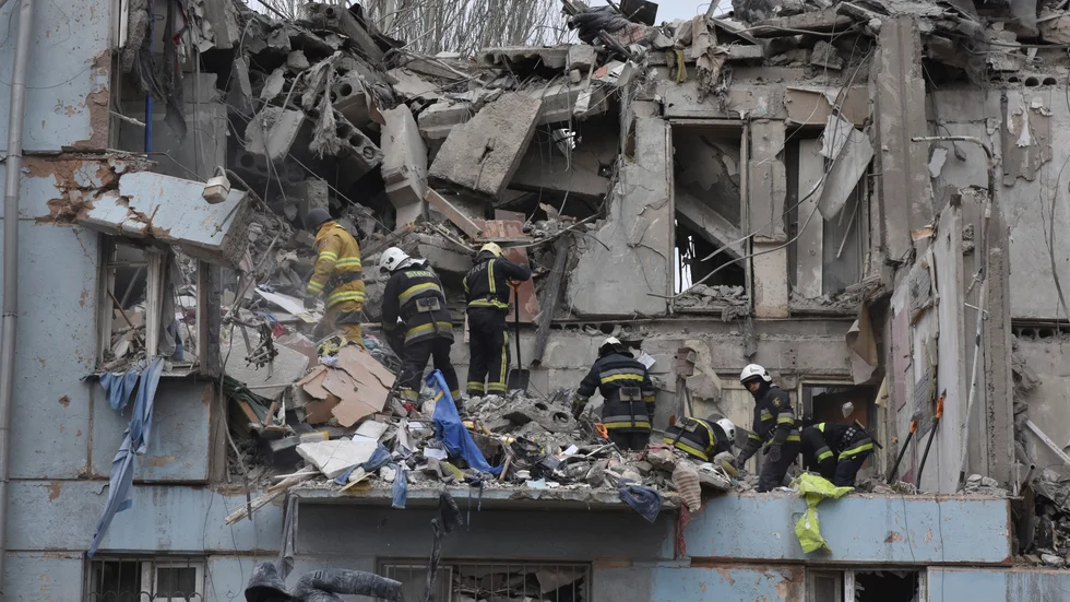 Ukrainsk räddningstjänst inspekterar ett bombat hus i Zaporizjzja på fredagen.