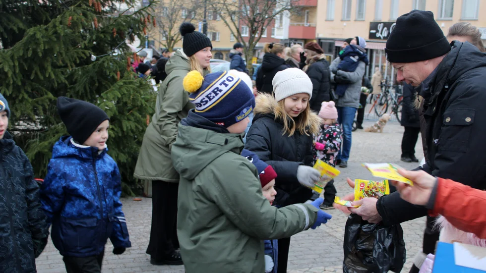 Michael Karlsson, aktivitetsansvarig i Vimmerby Handel, delar ut godis till deltagare i julgransplundringen förra året.