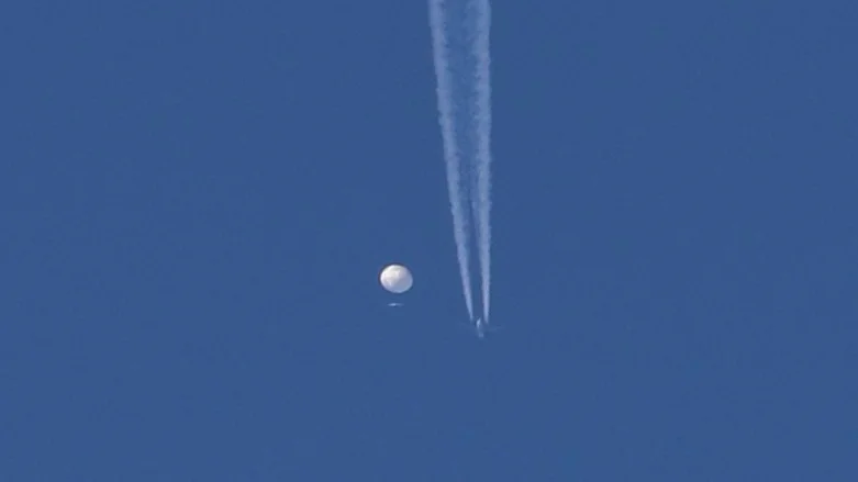 Ett militärflygplan flyger förbi den höghöjdsballong som syntes över USA, bara någon timme innan den sköts ner.