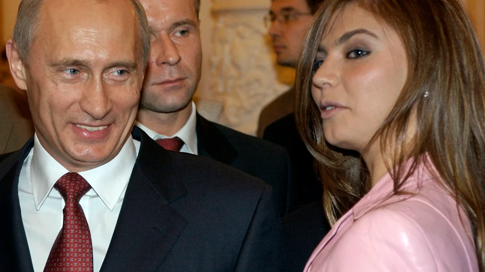 Vladimir Putin i samspråk med Alina Kabajeva på en bankett i Kreml i november 2004. Några år senare började ryktena om deras romans att florera. Arkivbild.