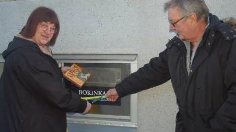 Smart lösning. Ett källarfönsterförvandlades till ett bokinkast. Bibliotekschef Kerstin Simberg klippte bandet och kollegan Anders Hördin assisterade.