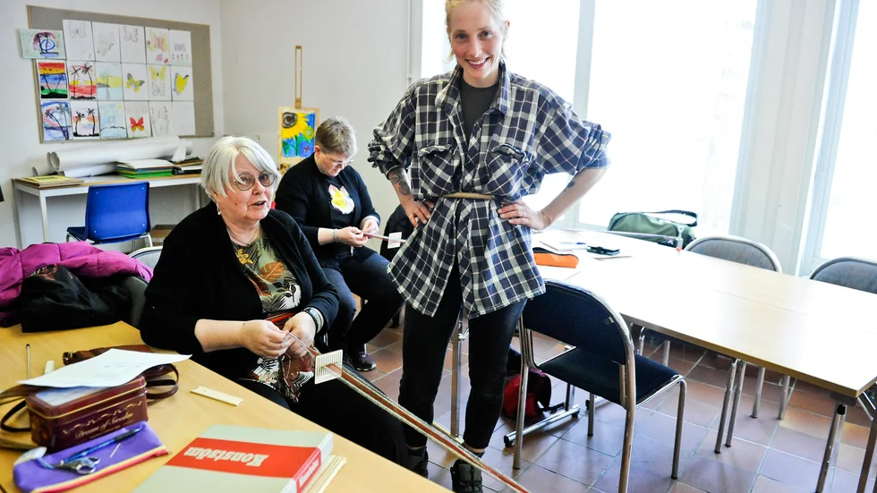 Agneta Eriksson väver ett band i olika färger och mönster. Kursledaren Hilde Opedal Nordby ger goda råd.