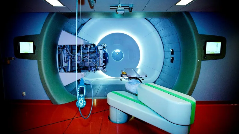 Behandlingsrummet. Här kommer patienterna att få sin cancertumör strålad med protoner. Till vänster sitter själva strålkanonen som kan roteras i hela den runda                       öppningen. Patienten dockas upp på industriroboten i förgrunden vars läge kan finjusteras i flera riktningar för att få optimal träff. Den ögonliknande fonden är en röntgenutrustning.