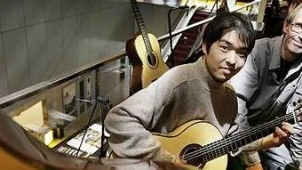 Masayuki Inagawa provar en av Thomas Fredholms gitarrer.