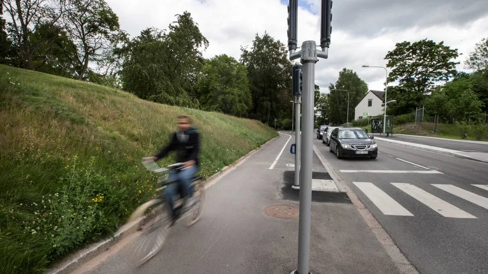I vägen. De nya trafikljusen i korsningen Norbyvägen/Dag Hammarskjölds väg har placerats mitt i cykelbanan. Cyklister tvingas nu svänga ut på gångbanan, närmast gräset, för att inte krocka.
