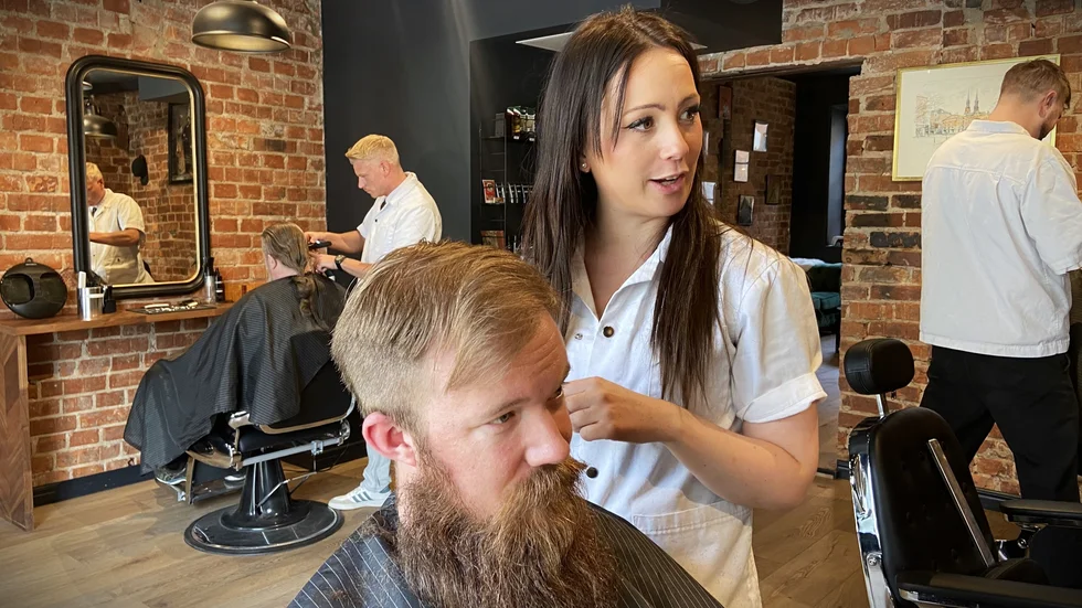 Emma Gällström är en av få kvinnliga barberare. Här klipper hon hår och skägg på stamkunden Pär Lindh.
