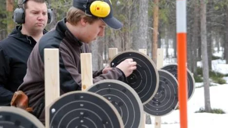 Patrik Karlberg, Arjeplog och Kim Lundgren från Boliden hjälps åt att läsa av tavlorna efter skjutningen.