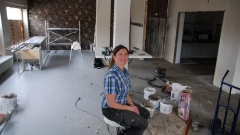Det råder organiserat kaos i lokalen som om ett par veckor ska bli ett kafé. "Tapeten i bakgrunden skvallrar lite om stilen på det som komma skall" säger Monika Olsson.