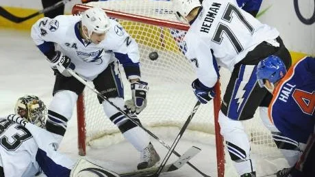 NÄTKÄNNING. Målvakten Dan Ellis, Johan Harju och Victor Hedman försöker stoppa Edmontons Taylor Hall från att göra mål - men misslyckas. På tisdagen  kallades Harju upp till NHL för tredje gången i höst.