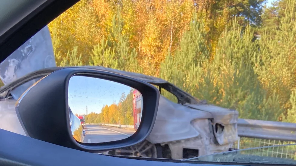 Här syns resterna av det fordon som vid 15-tiden eldhärjades på E20 i höjd med Strängnäs, och även Räddningstjänstens bil som fortfarande fanns kvar på platsen en timme efteråt. 