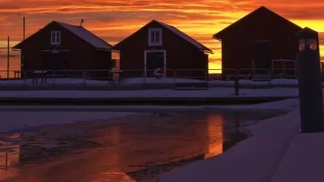 En "brinnande" himmel har här fångats i kameralinsen vid sjöbodarna i södra hamnen i Piteå.