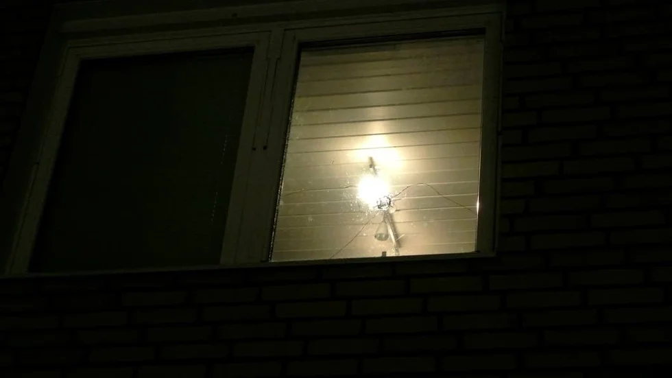 Skottlossning. Kulhål i lägenhetens fönster.
