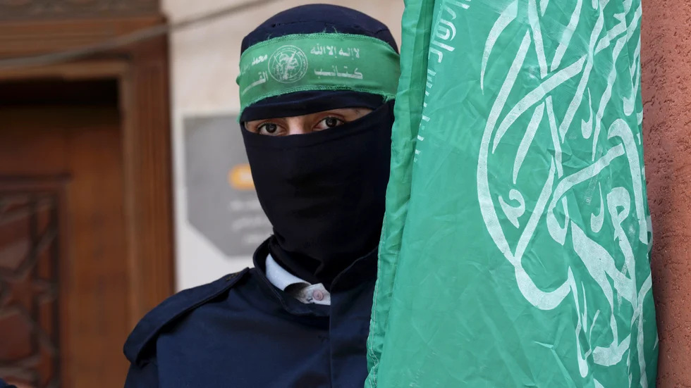 En medlem i den väpnade grenen al-Qassam-brigaderna med Hamas flagga, vid en demonstration mot Israel i Gazaremsan i våras.