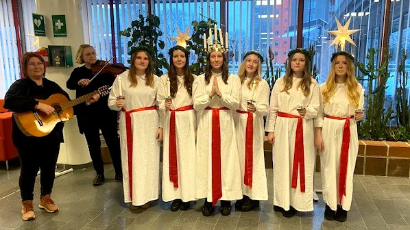 Lucian Olivia Strand och tärnorna på ett av många stopp under luciadagen. Här under framträdandet i kommunhuset.